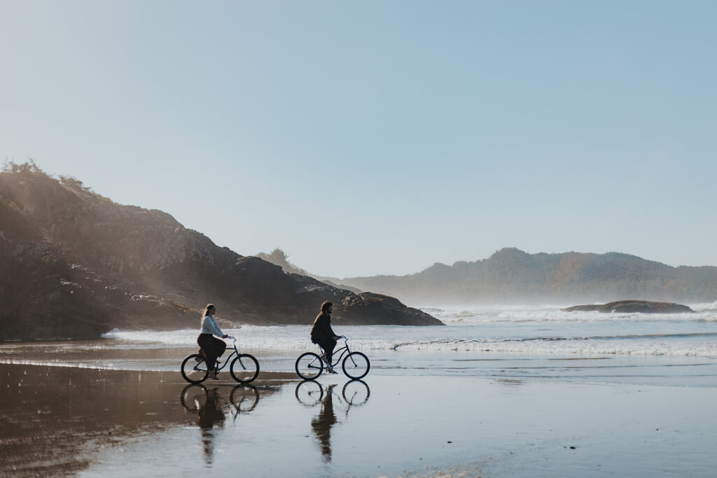 A couple bikes the beach in Tofino BC