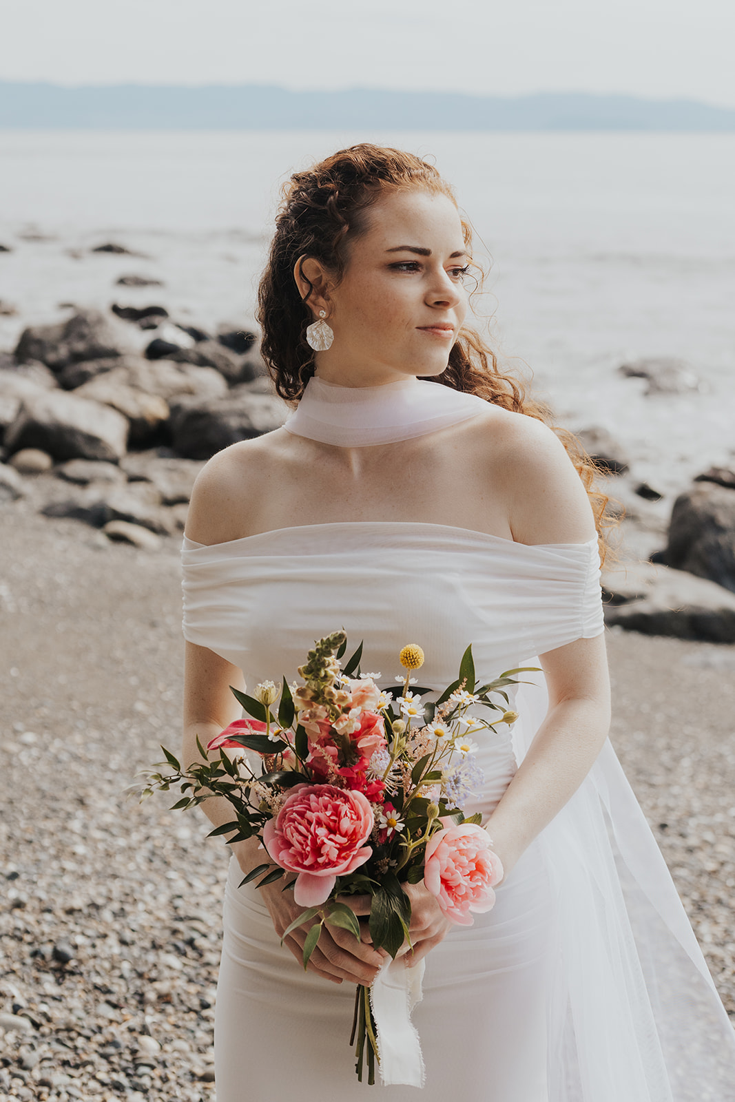 A bride walks along the beach in Jordan River, BC on her elopement day